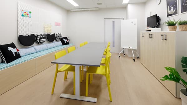 部屋中央に電動昇降デスクをおき、壁に沿って設置した収納付きベンチで自分の好きな場所で本が読める。