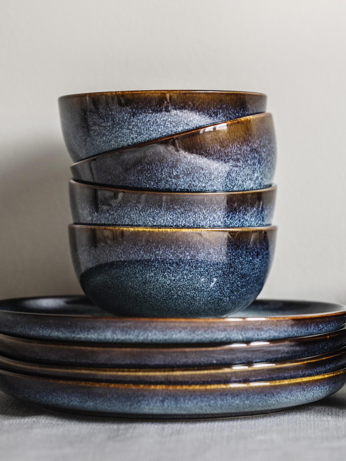 Niebieskie miski i talerze GLADELIG są ustawione jedno na drugim.