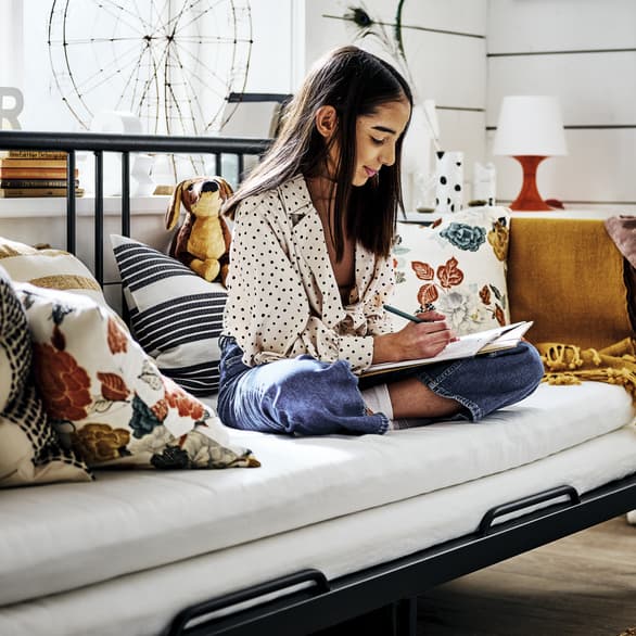 Niña escribiendo en su cuarto