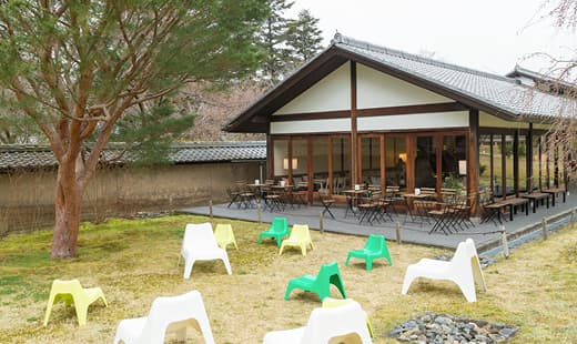 霊宝館にオープンしたカフェの外観。芝生に置いた屋外用のチェアは、置き場所を動かして風景を楽しめる。BUNSÖ/ブンソー、IKEA PS VÅGÖ/ヴォーゴー イージーチェア。
