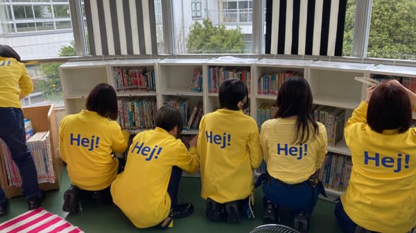 棚に本を入れているスタッフ6人。