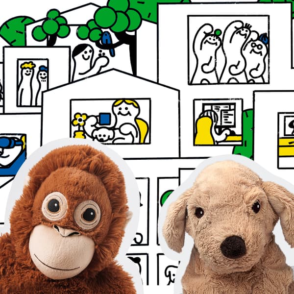 未来の家で家族が自分らしく暮らす様子を描いた絵本の中身。手前にオランウータンと犬のぬいぐるみ。