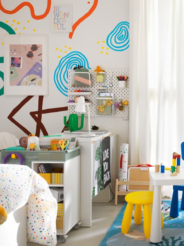 共用の子ども部屋で、ホワイトのMICKE/ミッケ デスクとÖVNING/オーヴニング ワゴンのそばに、MAMMUT/マンムット 子ども用家具が置いてある。