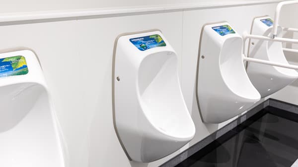 節水型の白い小便器がトイレの壁に並ぶ