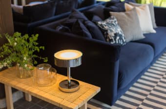 籐のコーヒーテーブルには、ガラスの花瓶とテーブルランプを。STOCKHOLM/ストックホルム 2017 コーヒーテーブル、CYLINDER/シリンデル 花瓶、TOCKHOLM/ストックホルム 2017 テーブルランプ。