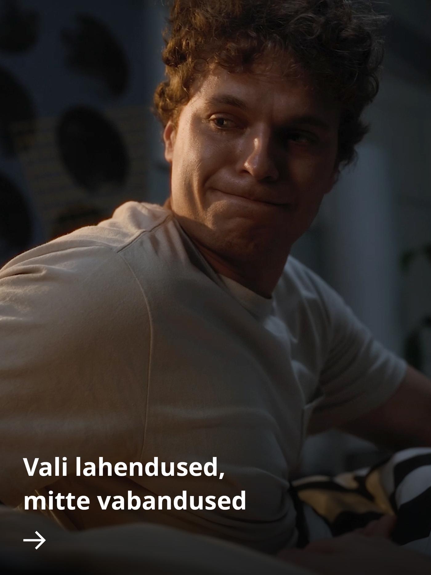 Noor lokkis juustega mees istub siseruumis sooja valguse käes, näeb välja emotsionaalne, kuid vaoshoitud; pildil on tekst: „Vali lahendus, mitte vabandus“.