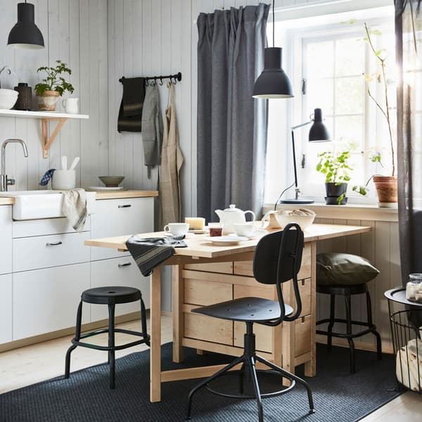NORDEN extendable pine table in a small open dining and kitchen space.