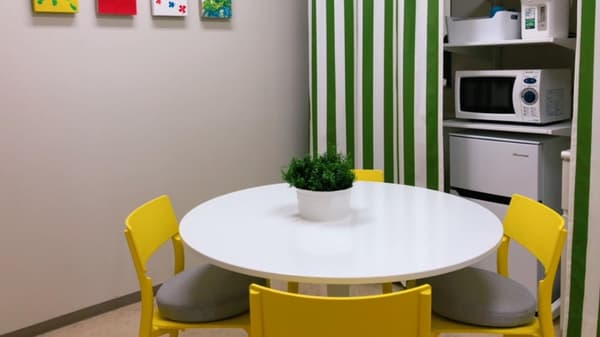 円卓の周りに黄色いダイニングチェアが並んでいるキッチンスペース。