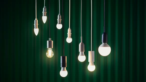 Nove lámpadas LED SOLHETTA penduradas do teito, diante dunha cortina verde.