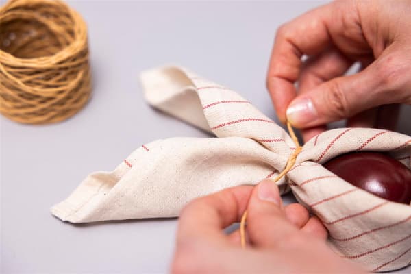 Now she ties the two ends together.