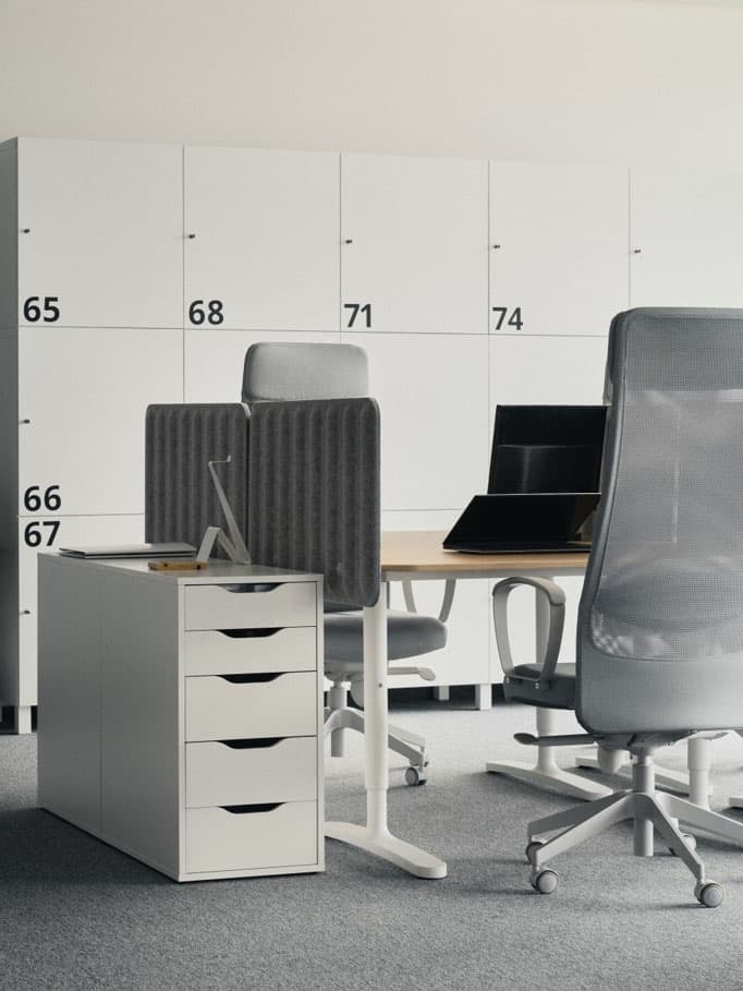 Nowoczesne biuro z szarymi krzesłami, biurkami i białymi szafkami z numerami.