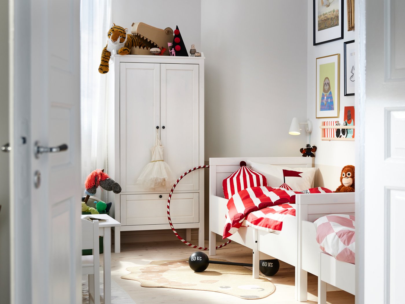 Nun dormitorio, dúas camas extensibles SUNDVIK pegadas ao longo dunha parede, á beira dun armario SUNDVIK branco.