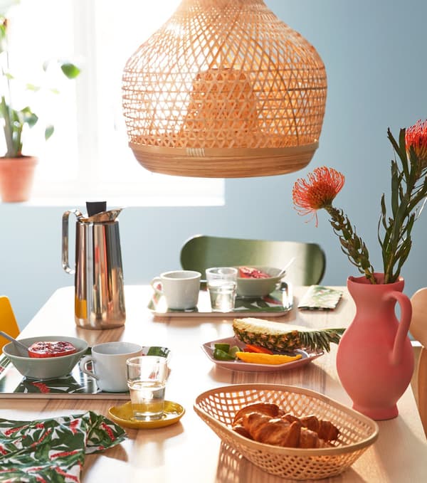 Nyárias hangulatú kiegészítők az étkezőasztalon, bambuszból készült lámpa és tálca.