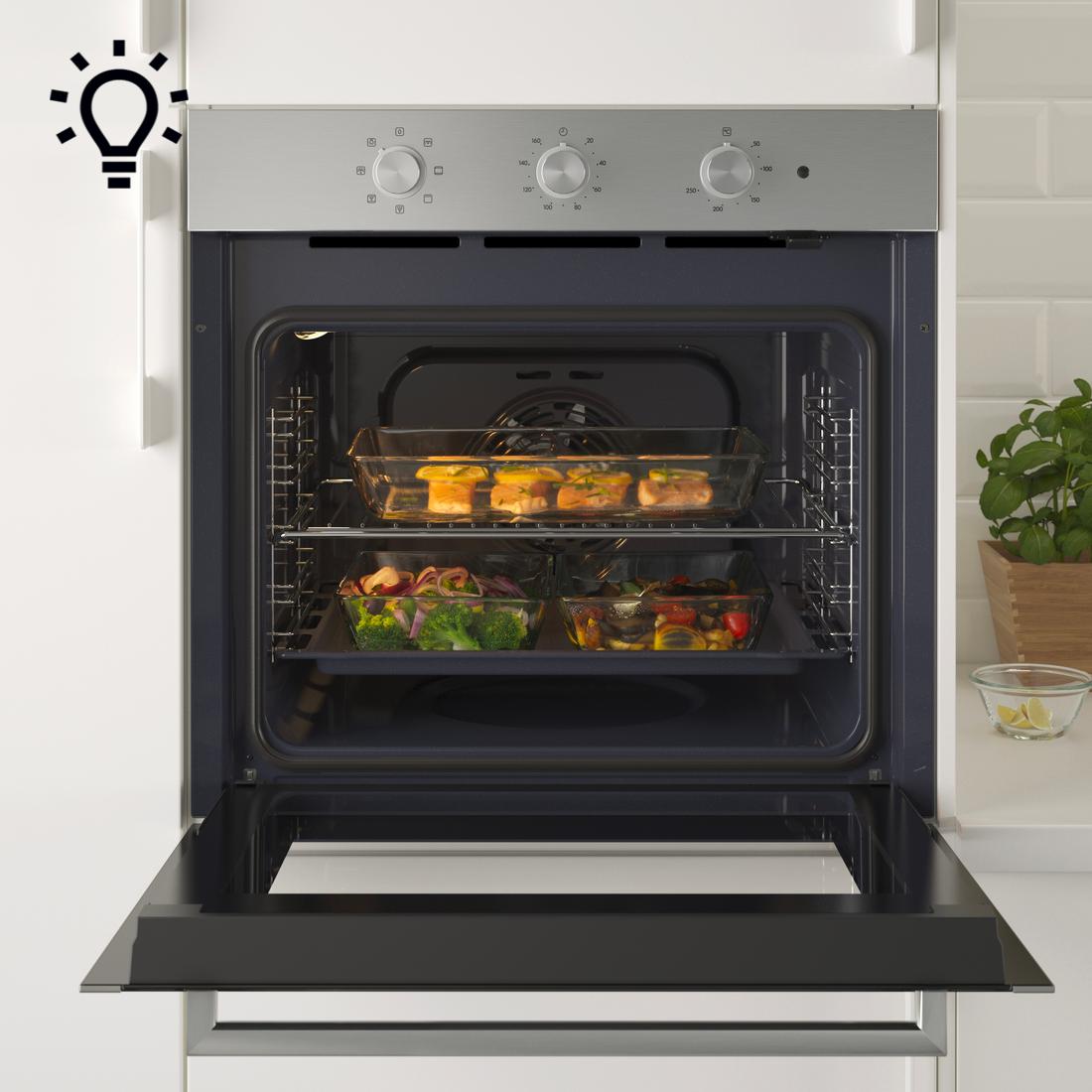 Nyitott sütő, tele étellel teli tepsikkel.