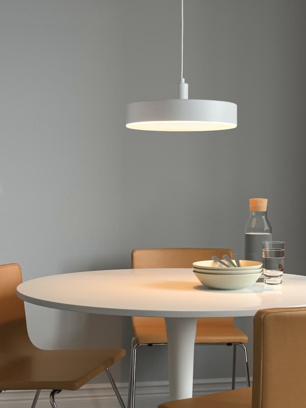 NYMÅNE pendant lamp on top of a round dining table with chairs. 