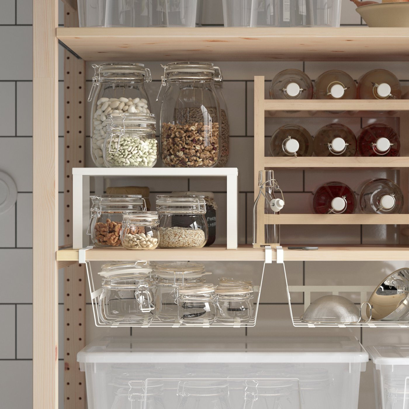 O cămară cu polițe IVAR și coșuri suspendate PÅLYCKE și organizatoare VARIERA pe care sunt depozitate sticle și borcane.