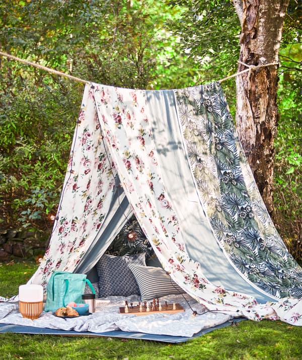 O frânghie între doi copaci și bucăți lungi de material, de exemplu din metrajul  multicolor EMMIE ROS, pot fi folosite pentru a realiza corturi pentru picnic vara.  