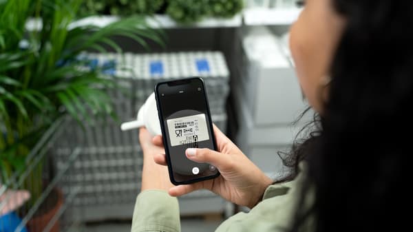 O persoană scanează un cod de bare al unui produs IKEA cu telefonul într-un magazin.