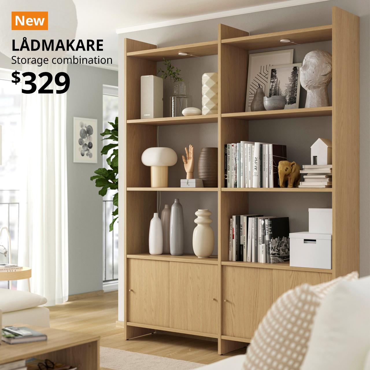 Oak effect LÅDMAKARE storage combination with sliding doors in a living room setting. An orange "NEW" label is on the top left of the image with black text that reads: LÅDMAKARE, Storage combination, $329.