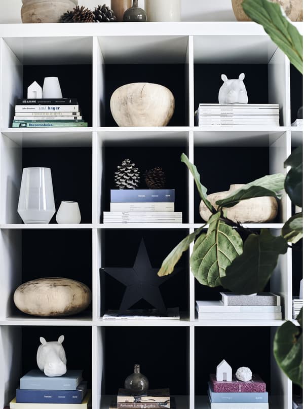 Objects and magazines displayed on a white storage unit.