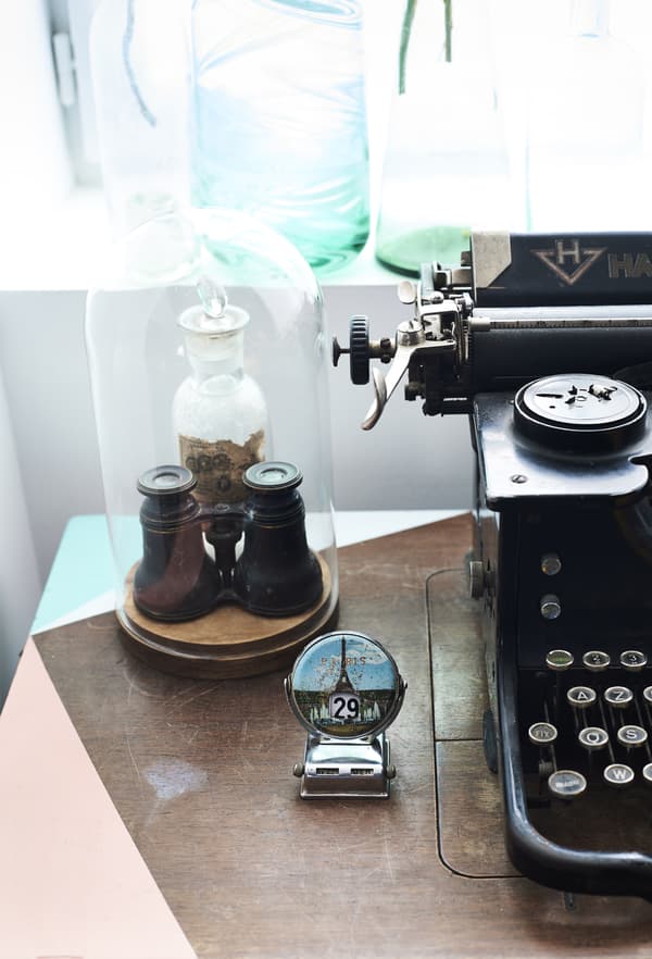 Objets anciens sous un cloche en verre et machine à écrire vintage
