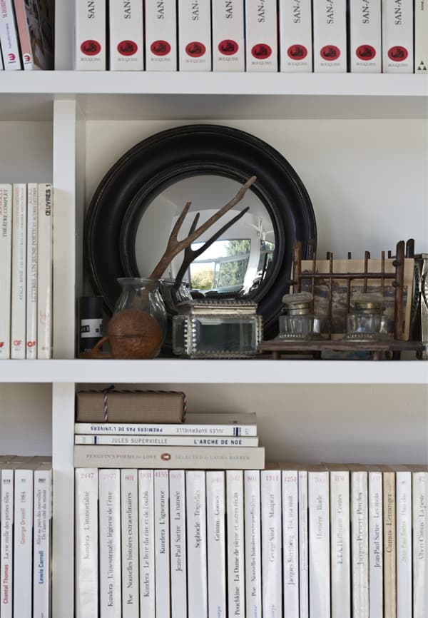 Objets et miroir exposés sur une bibliothèque