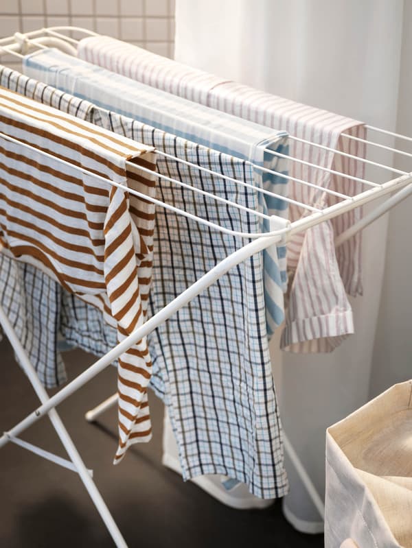 Oblečenie sa suší na bielom sušiaku na bielizeň JÄLL.