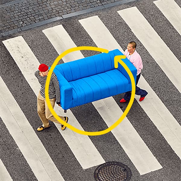  Oby niosące niebieską kanapę przez przejście dla pieszych.