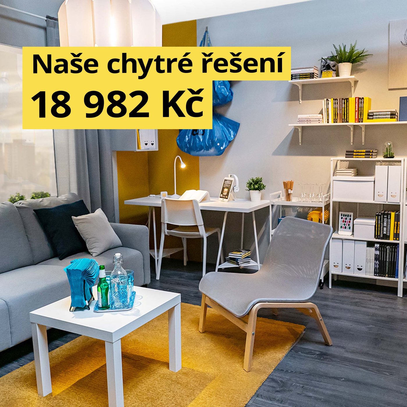 Obývací pokoj s pohovkou, křesly a pracovním koutem v modro-šedé barevné kombinaci.