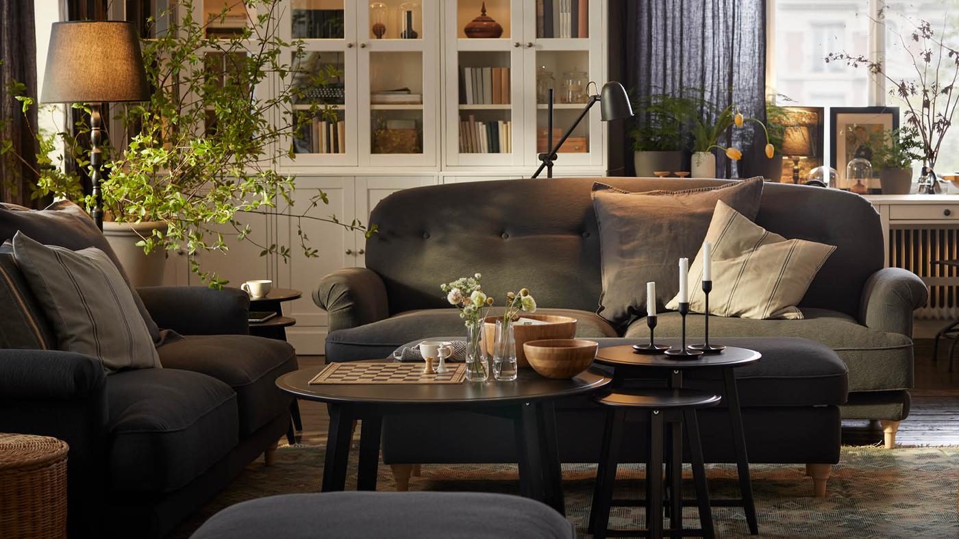 Obývacia izba s dvomi tmavosivými pohovkami ESSEBODA, v pozadí stojí biela úložná zostava HAVSTA.