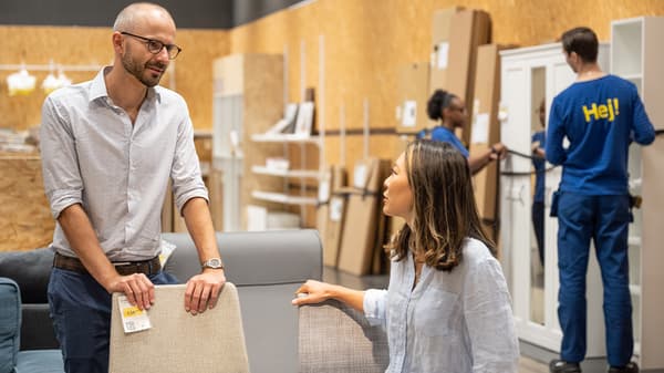 Oddělení zlevněného zboží, osoby nakupující zboží, zaměstnanci IKEA v pozadí