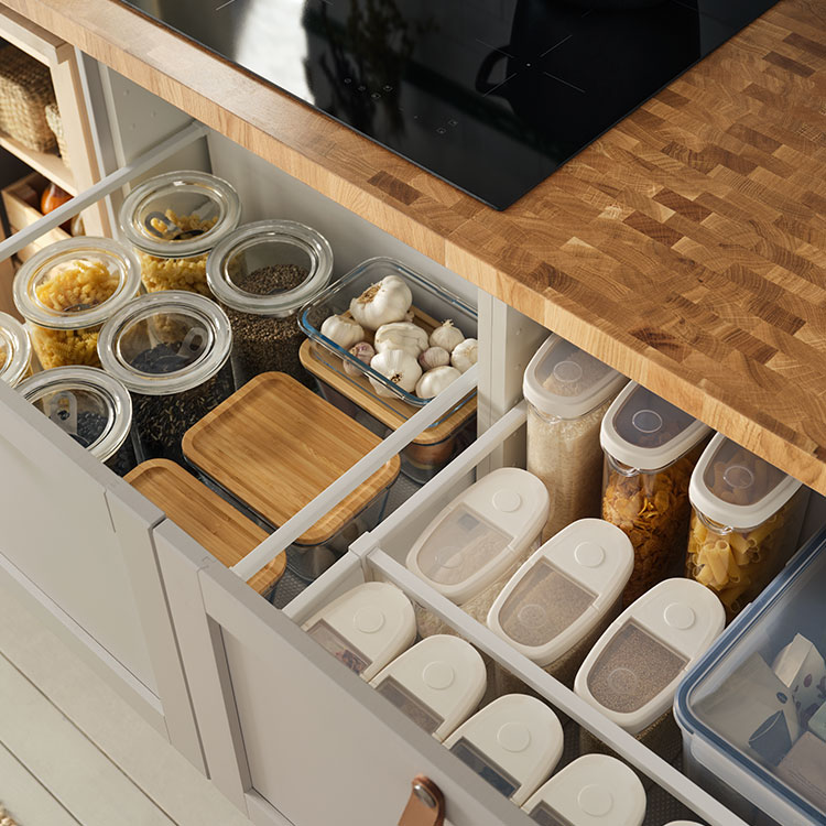 Offene Schubladen, in denen Vorräte ordentlich und nachhaltig in Vorratsbehältern sortiert sind.