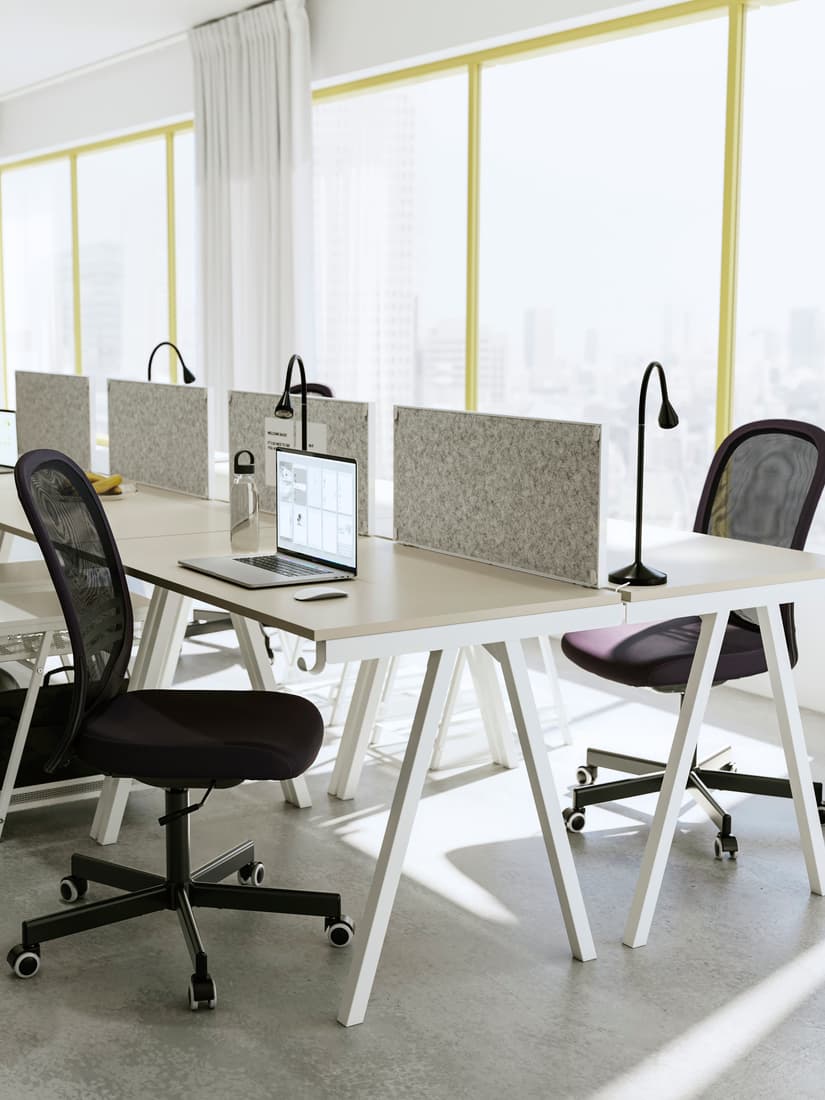 Oficina en la que se muestran dos puestos de trabajo uno frente al otro. Con sillas reclinables y un computador al frente.