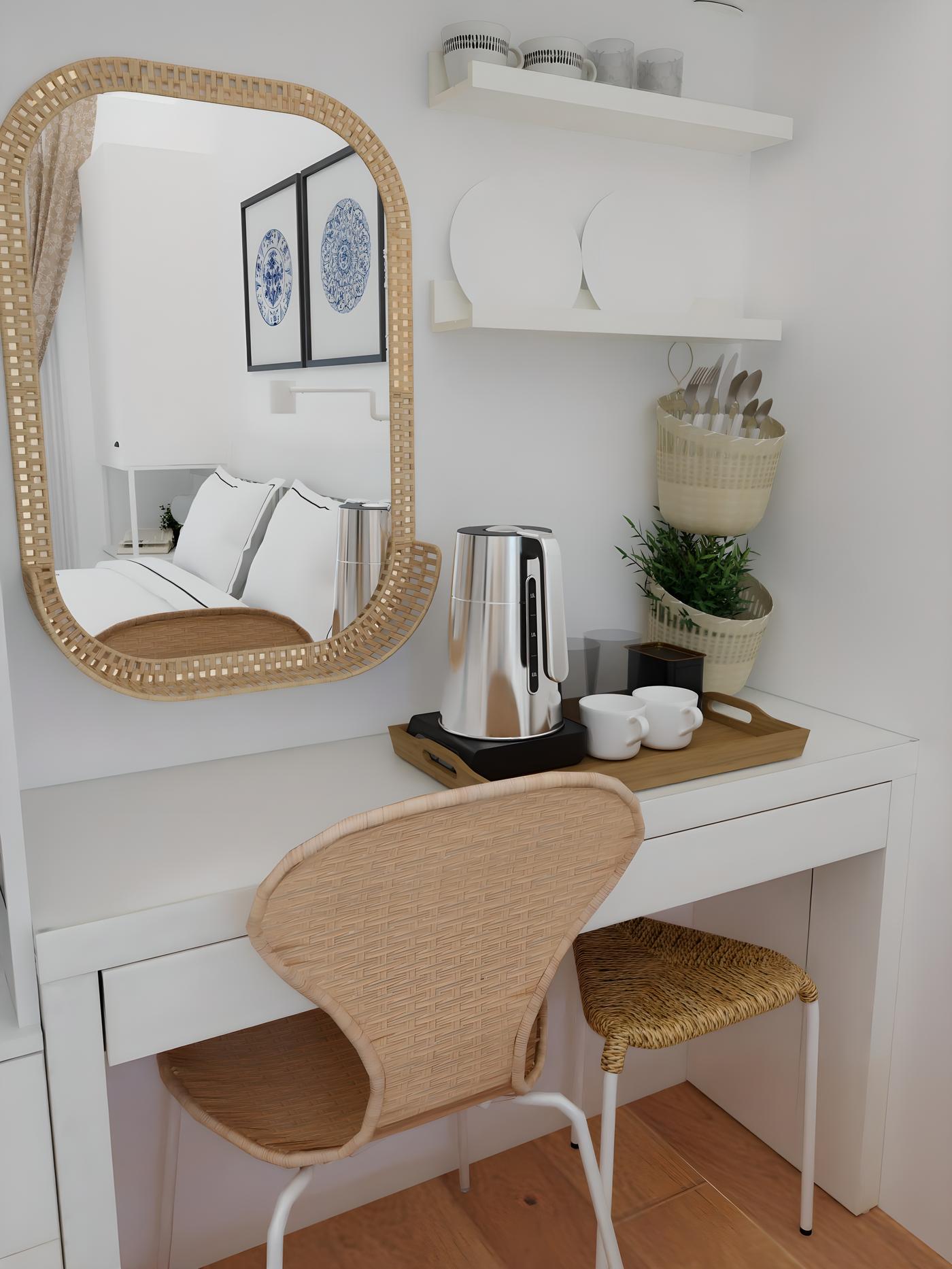 Ogledalo iznad bijelog stola s ratan stolicom, pored aparata za kavu i šalice.