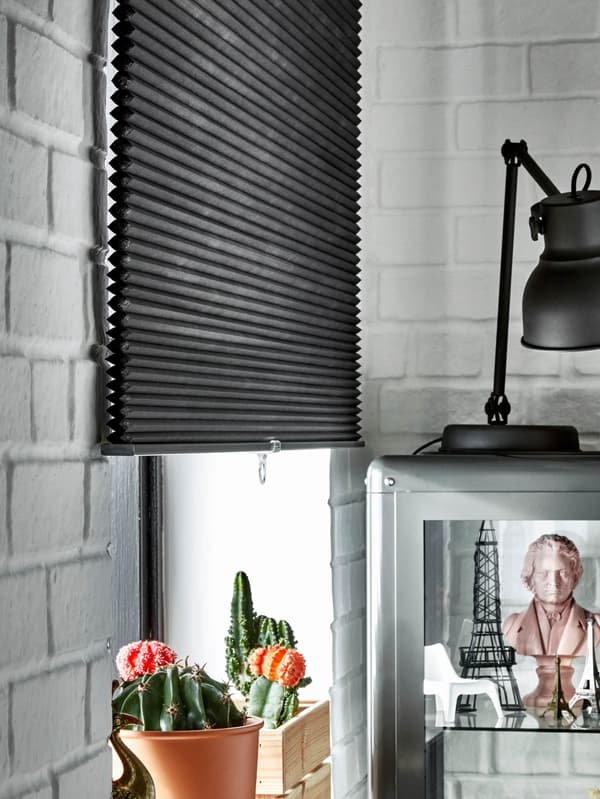 Okno s čiernou izolačnou roletou HOPPVALS.