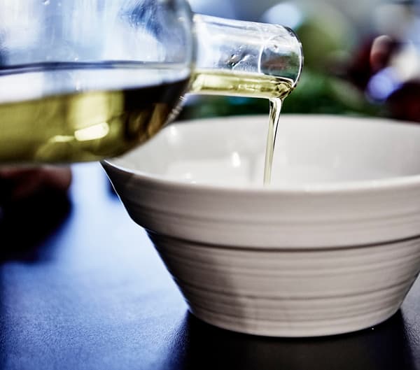 Olive oil being poured into a ceramic bowl