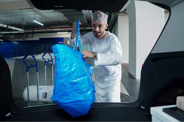 Omani collecting order into car trunk