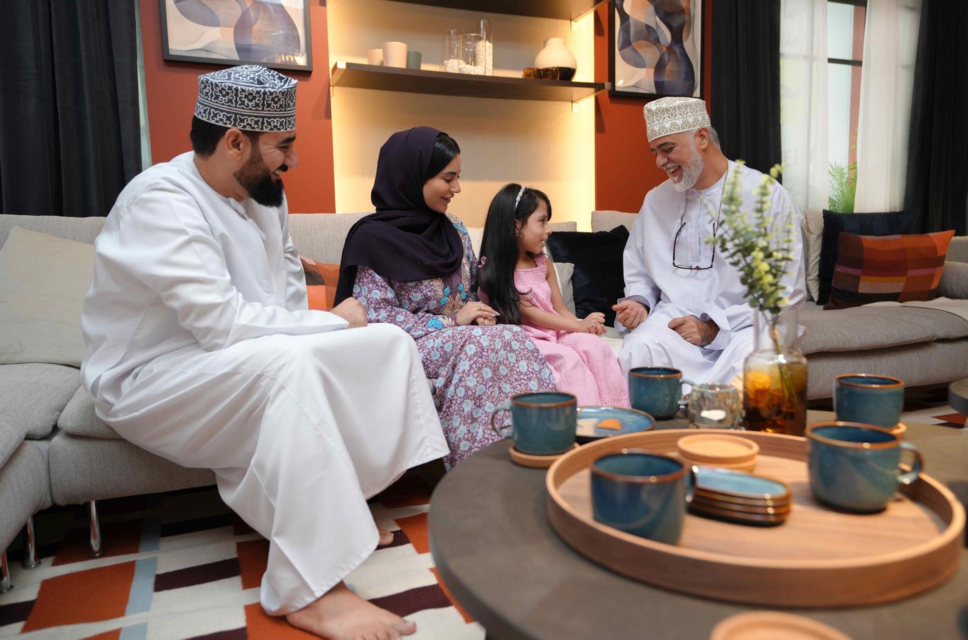 Omani family sitting in the living room sharing talks and exchanging laughter