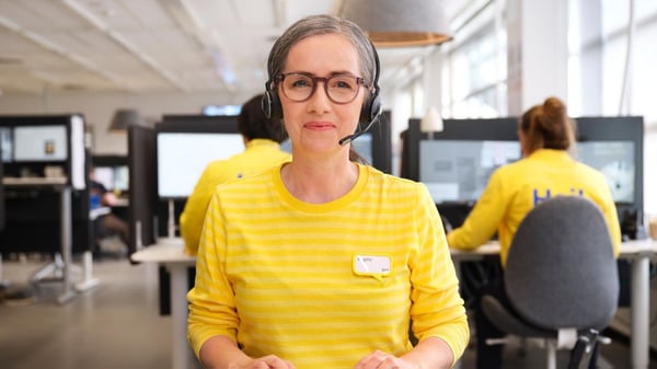 Online specialist sitting at desk taking a call.