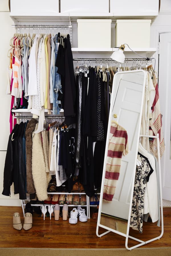 Opbergruimte waar allemaal kleding hangt en schoenen onder staan.