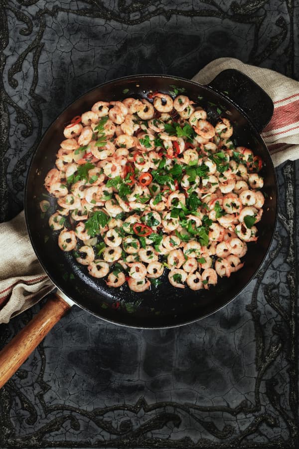 Opečené krevety s čili a cesnakom na panvici.