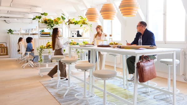 Open office space with a high table and people working 