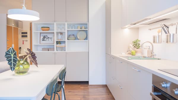 Open-plan kitchen with dining area and wall-mounted cabinets.