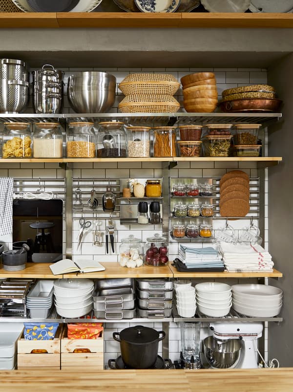 Open storage pantry kitchen wall with KUNGSFORS shelves, full of dry products in jars and kitchen accessories.