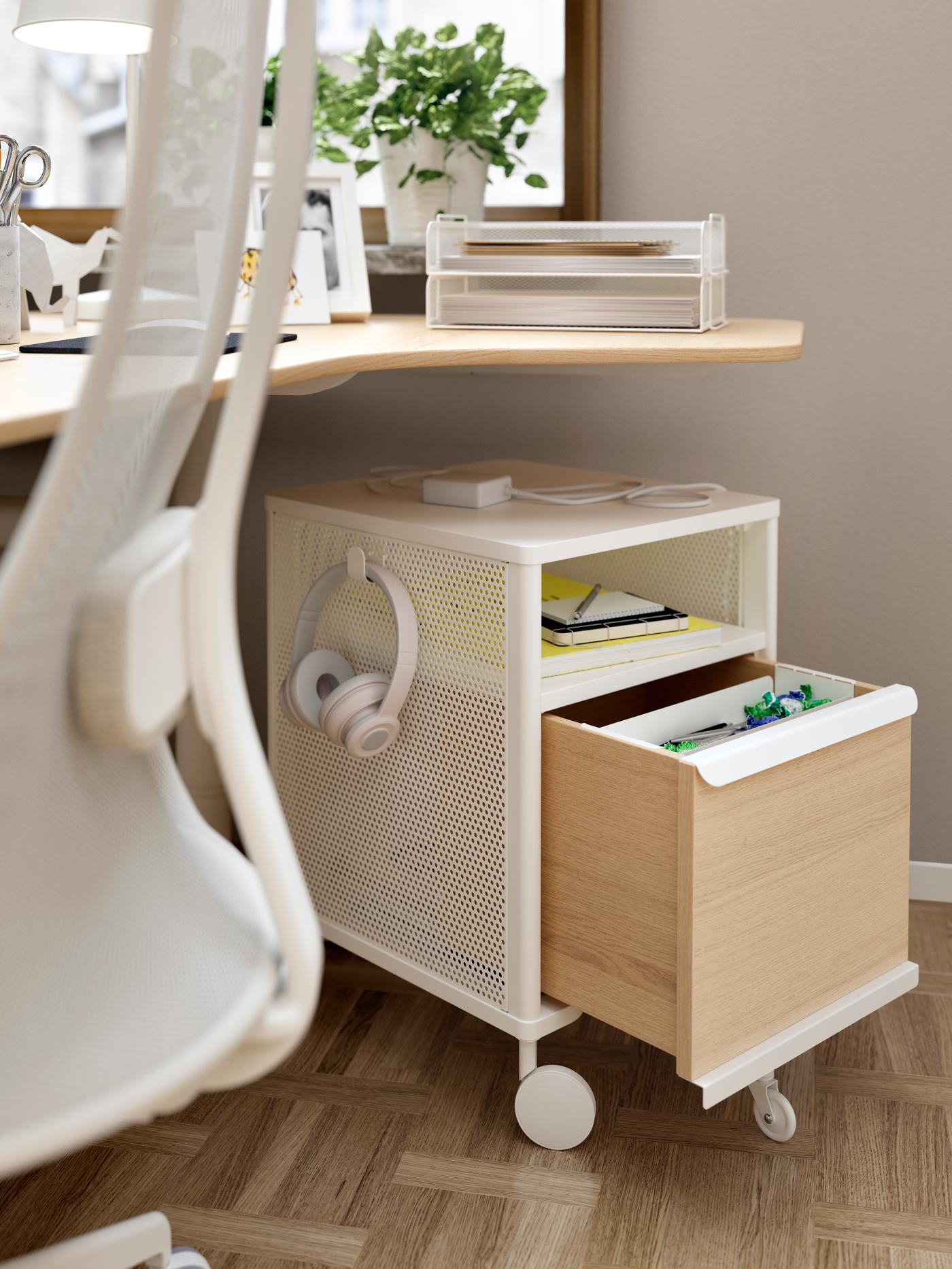 Open wit ladeblok op wieltjes waaraan een koptelefoon hangt.