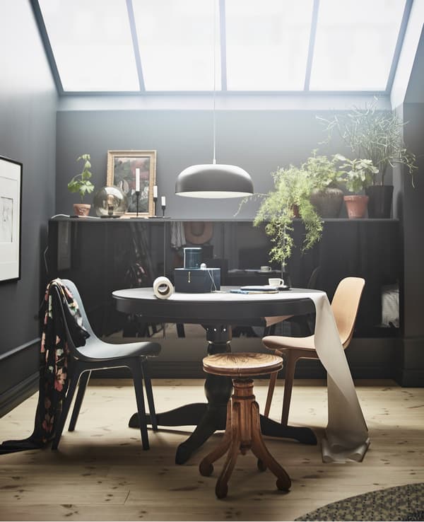 Optez pour une approche non conventionnelle du mobilier de chambre foncé en important des pièces de la salle à manger ou de la cuisine, pour créer un coin repas/travail. La table extensible INGATORP de chez IKEA a un look traditionnel et un plateau rond en placage de frêne teinté noir.