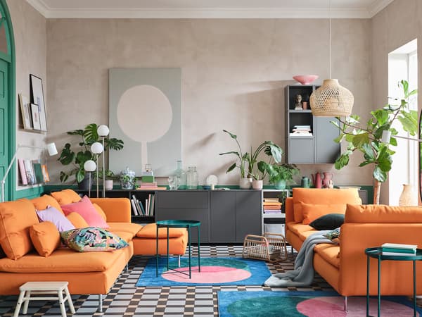 Orange SÖDERHAMN sofa creates a tropical theme with plants and neutral frames and walls.
