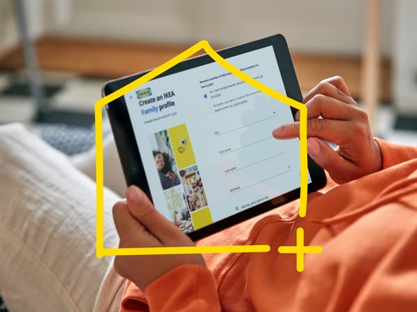 Oranssipaitainen henkilö pitelee käsissään tablettia.