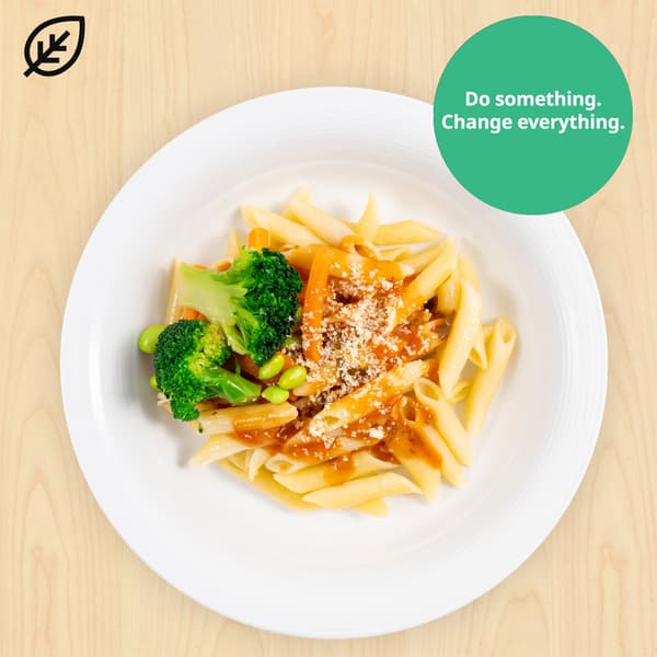 Organic penne pasta with tomato sauce and mixed vegetables with plant food symbols at top left corner. A green sustainable tag is on the top right hand corner of the dish that reads 
