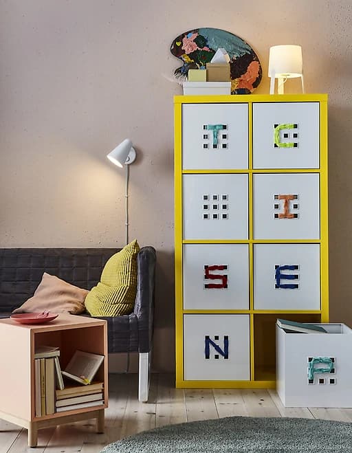 Organise your library with book storage boxes like white plastic LEKMAN box from IKEA. It has felt pads underneath, and you can add labels by threading through the premade holes. The boxes help make a room feel calm and hide those guilty pleasures.